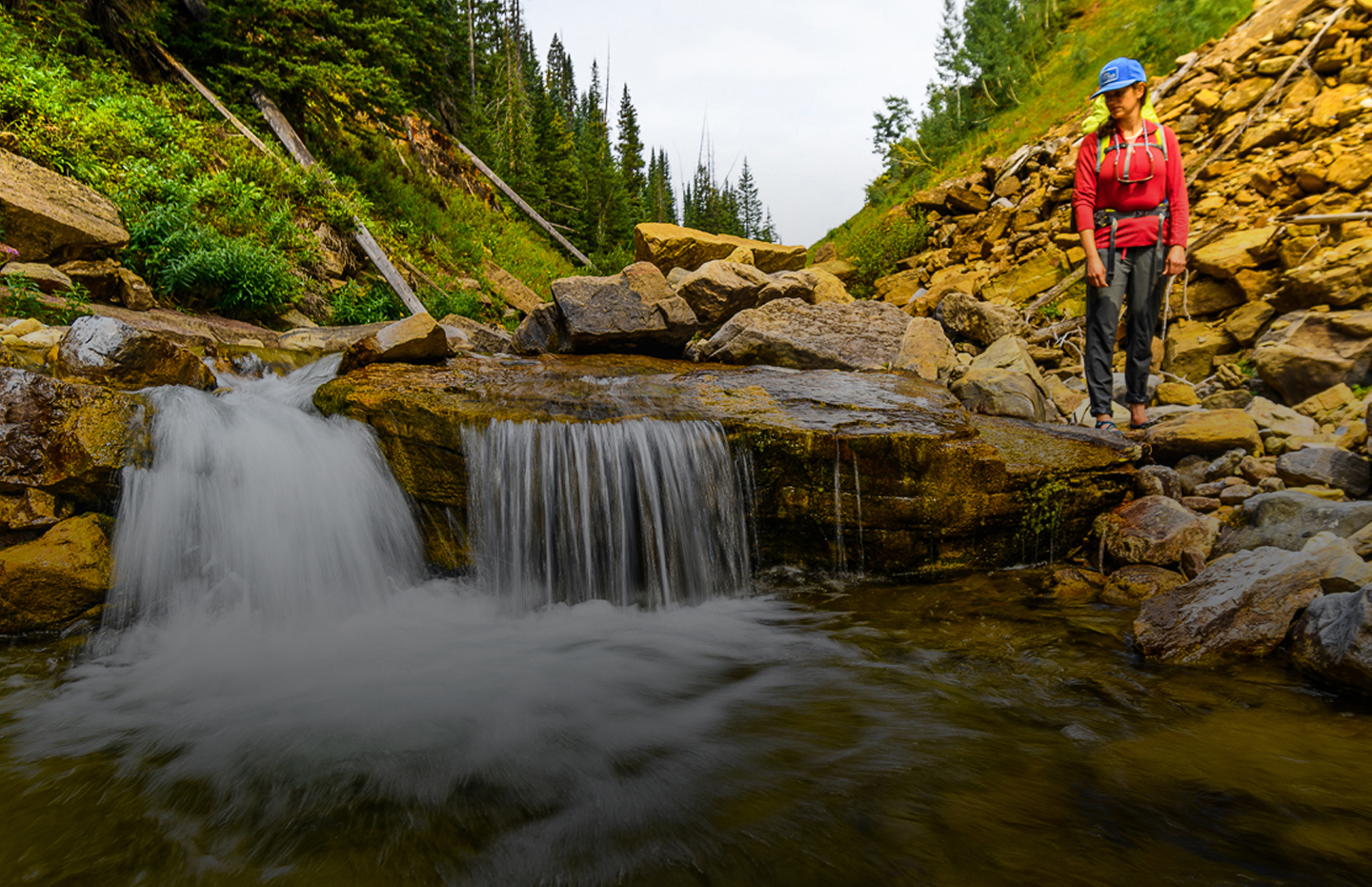 Backpacker looking down at waterfall