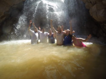 RRAFT participants enjoy a dip in a waterfall. | Dan Omasta