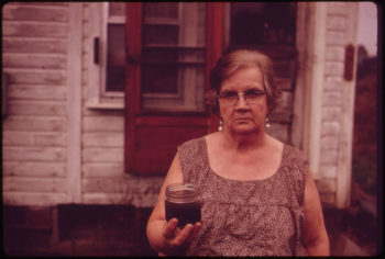 Mary Workman holds a jar of undrinkable water that comes from her well, and has filed a damage suit against the Hanna Coal Company, October 1973. | Erik Calonius / EPA