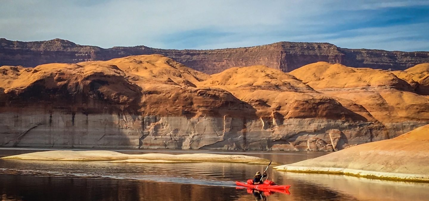 Kayaker paddles in front of Lake Powell’s substantial ‘bathtub ring.’ | Photo: Sinjin Eberle