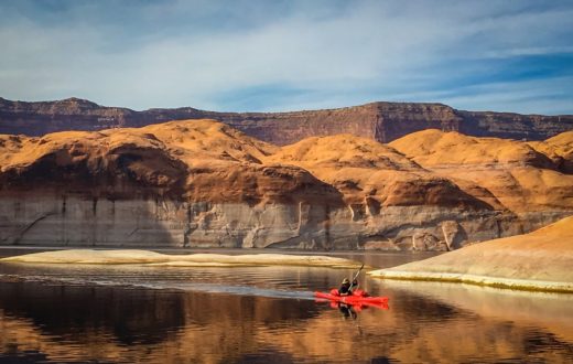Kayaker paddles in front of Lake Powell’s substantial ‘bathtub ring.’ | Photo: Sinjin Eberle