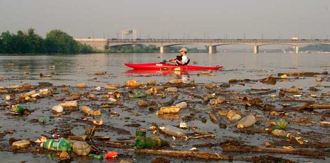 Kayaking around trash in the Anacostia River. | Photo: National Geographic/Skip Brown
