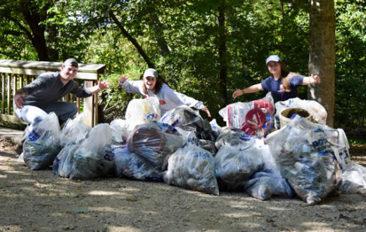 Volunteers pose with trash at a National River Cleanup event on Teddy Roosevelt Island, DC. | Rebecca Long