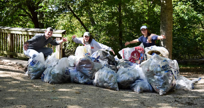 Volunteers pose with trash at a National River Cleanup event on Teddy Roosevelt Island, DC. | Rebecca Long