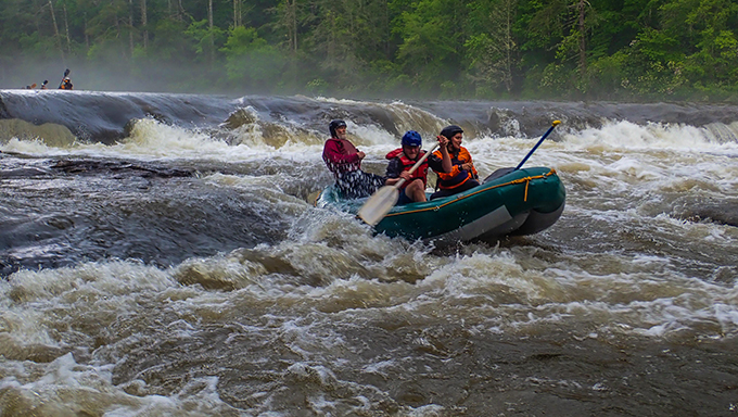 Melissa Martinez, Mike Huffman and local-legend Bruce Hare power through Dick’s Creek Ledge on a high-water Section 3 of the Chattooga. | Credit: Jack Henderson